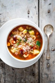 minestrone soup in a white bowl on a gray background
