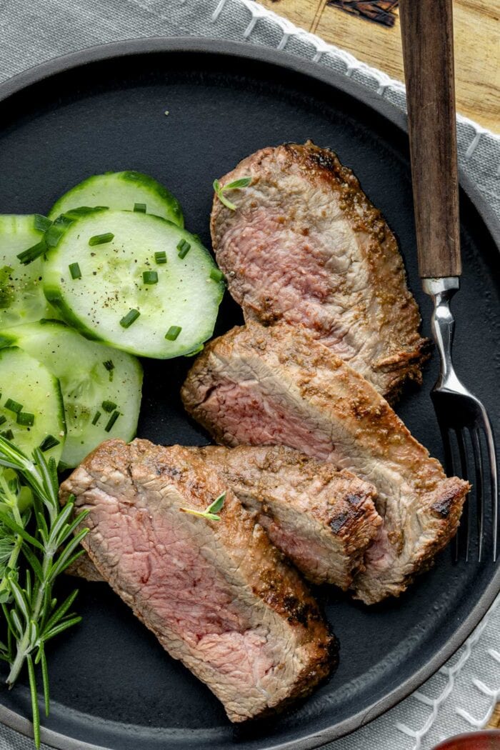 close up of the sliced steak on a black plate