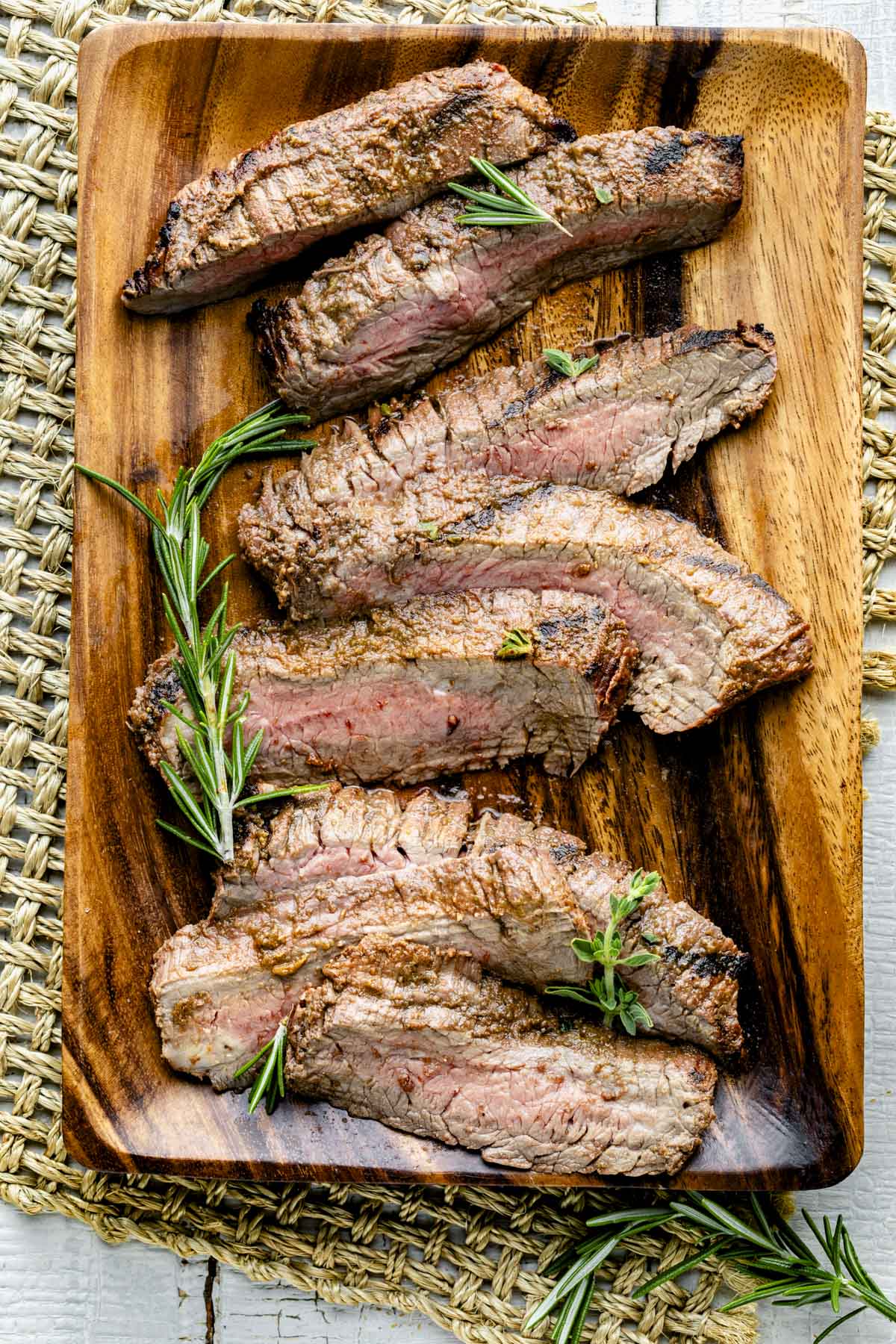 the sliced flank steak on a wooden plate