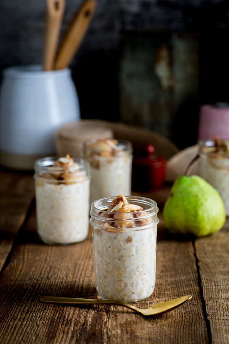 Pear Overnight Oats in jars alongside a pear