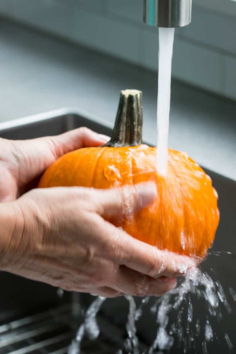 Wash your fresh cooking pumpkin before you peel, seed and cut it.