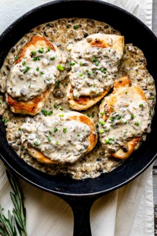 pork chops with mushroom gravy in a black cast iron skillet