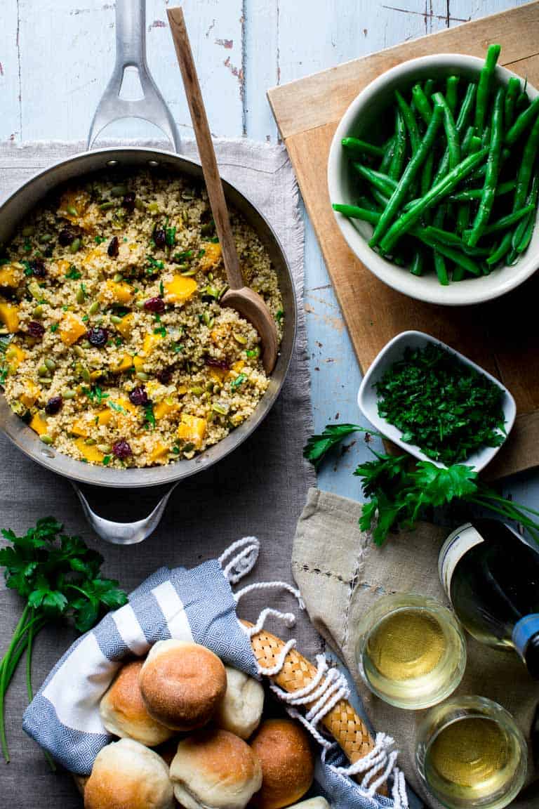 Pumpkin Pilaf in a pot alongside green beans and bread rolls