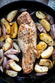 cast iron skillet with rosted pork tenderloin with apples and shallots coated in maple mustard sauce