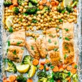a close up of the salmon on the sheet pan with the mocorccan spiced veggies and chickpeas