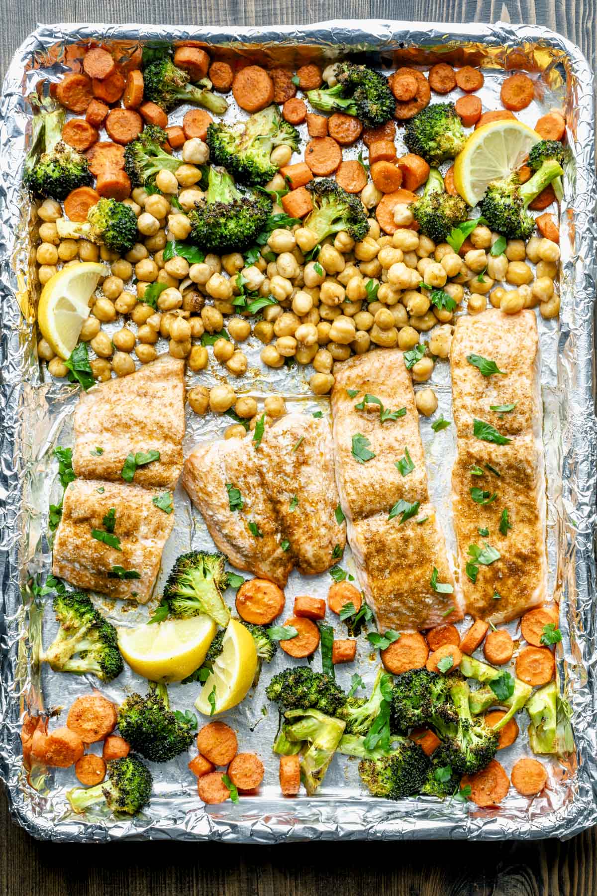 a close up of the salmon on the sheet pan with the mocorccan spiced veggies and chickpeas
