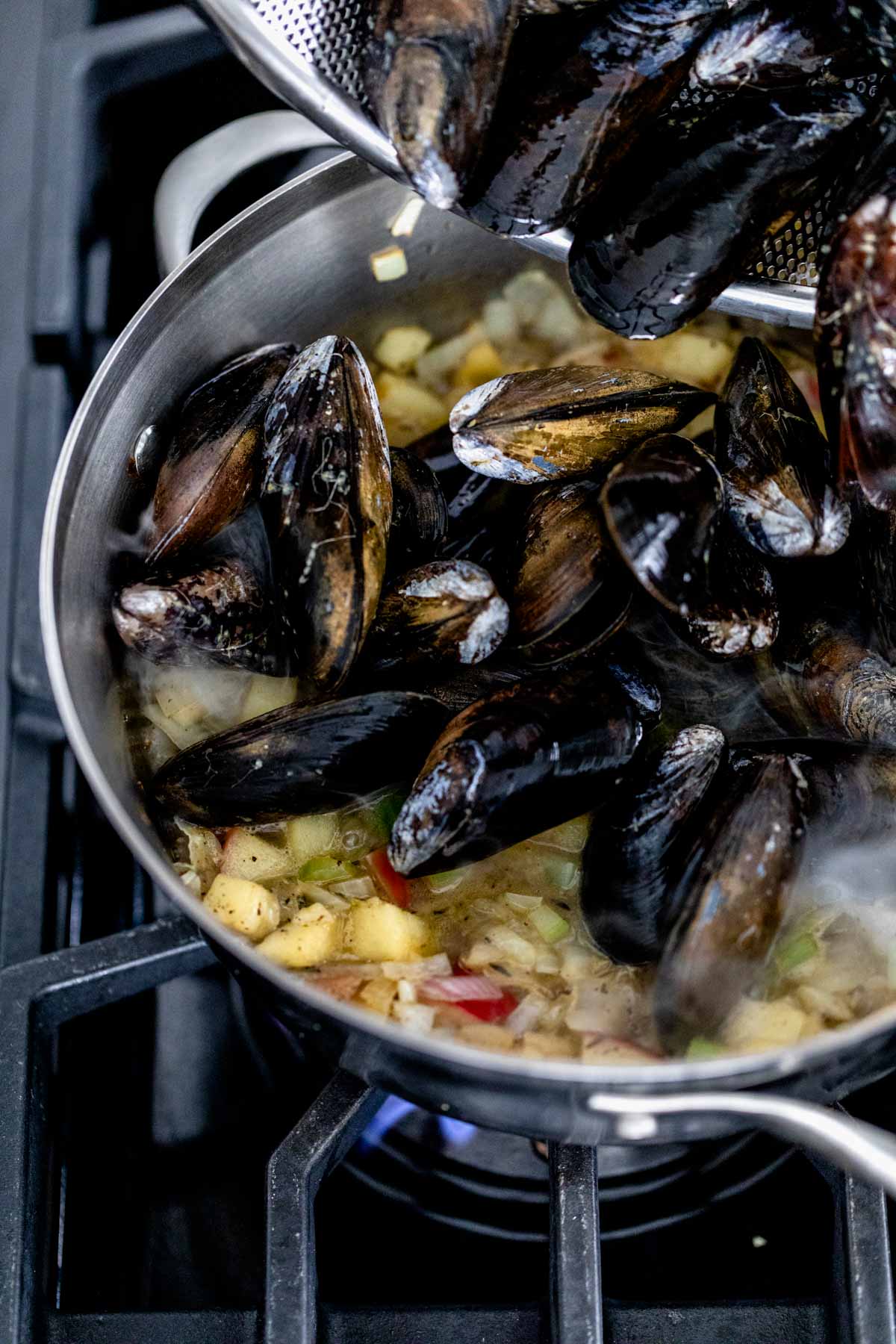 Add the mussels to the simmering liquid.