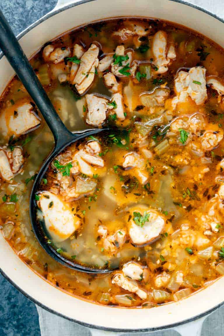 Close up of keto chicken soup and black ladle in a pot