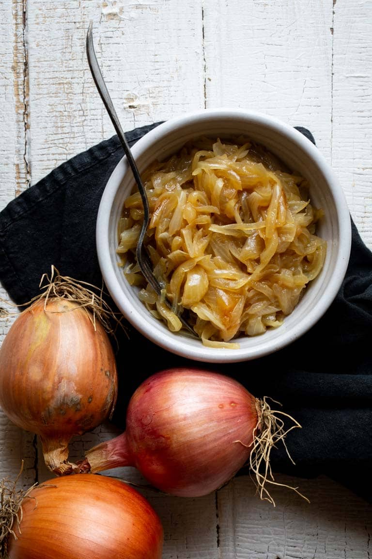 From hair growth to curing a common cold, there are many questions about these staple veggies. Ever wondered where onions came from? Or how do onions grow? And then there is the ongoing question of how do you caramelize one, or can onions be frozen? Look no further than this Ultimate Guide to Onions to learn everything about growing, cooking and nourishing about these lovely alliums. | Healthy Seasonal Recipes by Katie Webster #onions #caramelize #dice #producespotlight #seasonal
