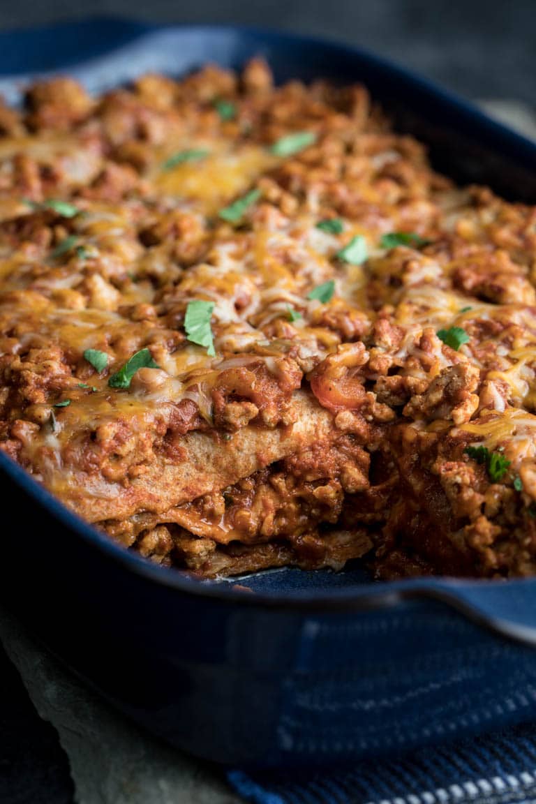 Layered Chicken Enchilada Casserole in a baking dish