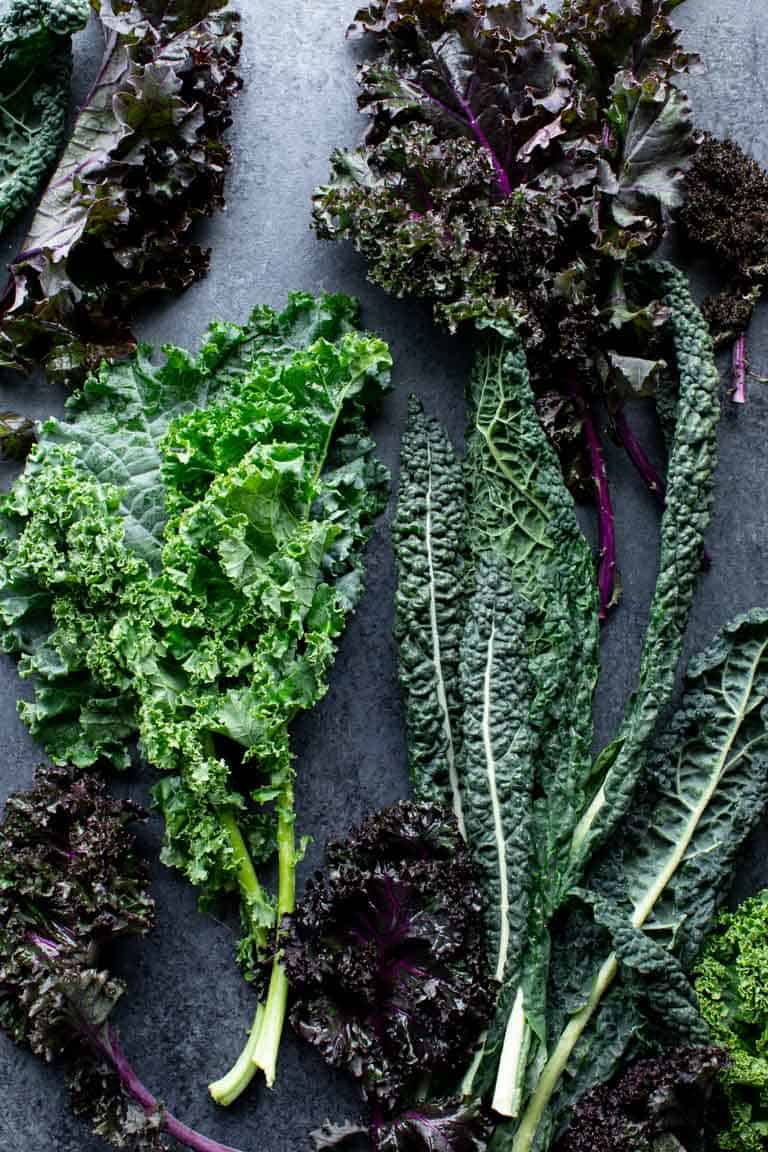 several types of kale on black surface