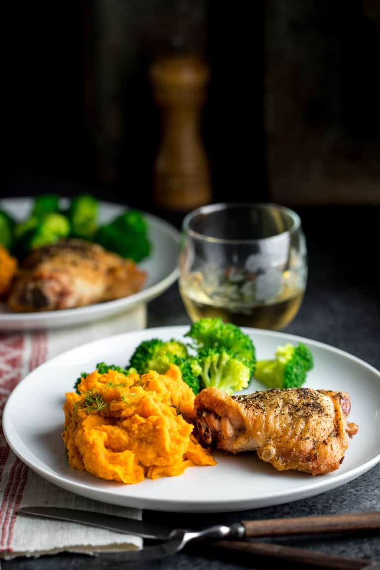 A dinner plate with crispy skin chicken, broccoli and mashed carrots and parsnips
