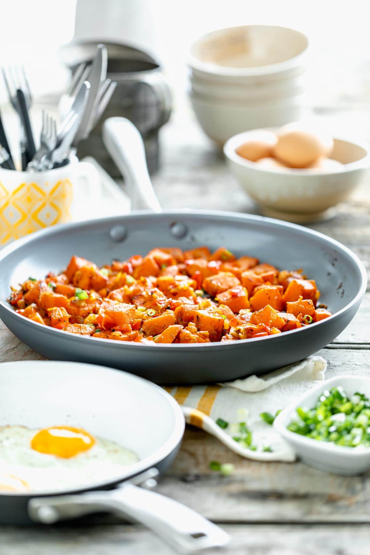side view of the table scape with eggs and skillet of sweet potato hash