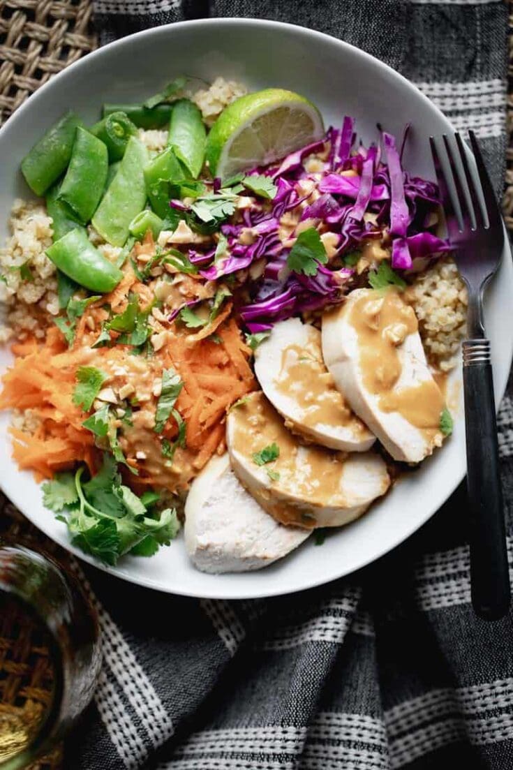 a close up of chicken quinoa bowl with peanut dressing