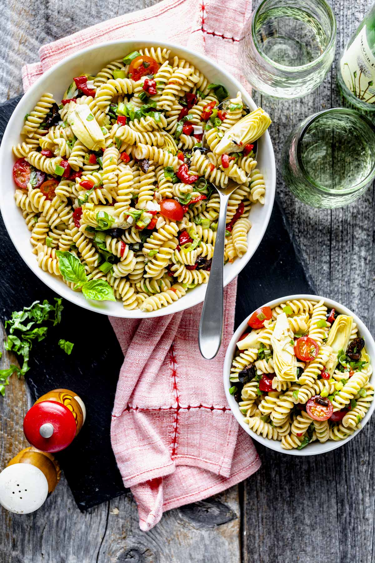 the pasta salad on the table from overhead with a smaller portion in a bowl next to it