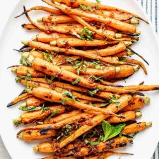 grilled carrots on a white platter