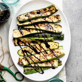 Grilled zucchini from overhead with green scissors, twine and clippings from the garden