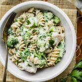 a bowl of chicken alfredo with broccoli