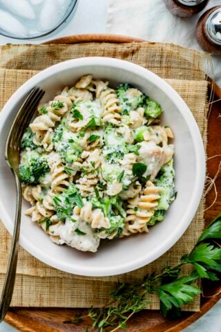 a bowl of chicken alfredo with broccoli