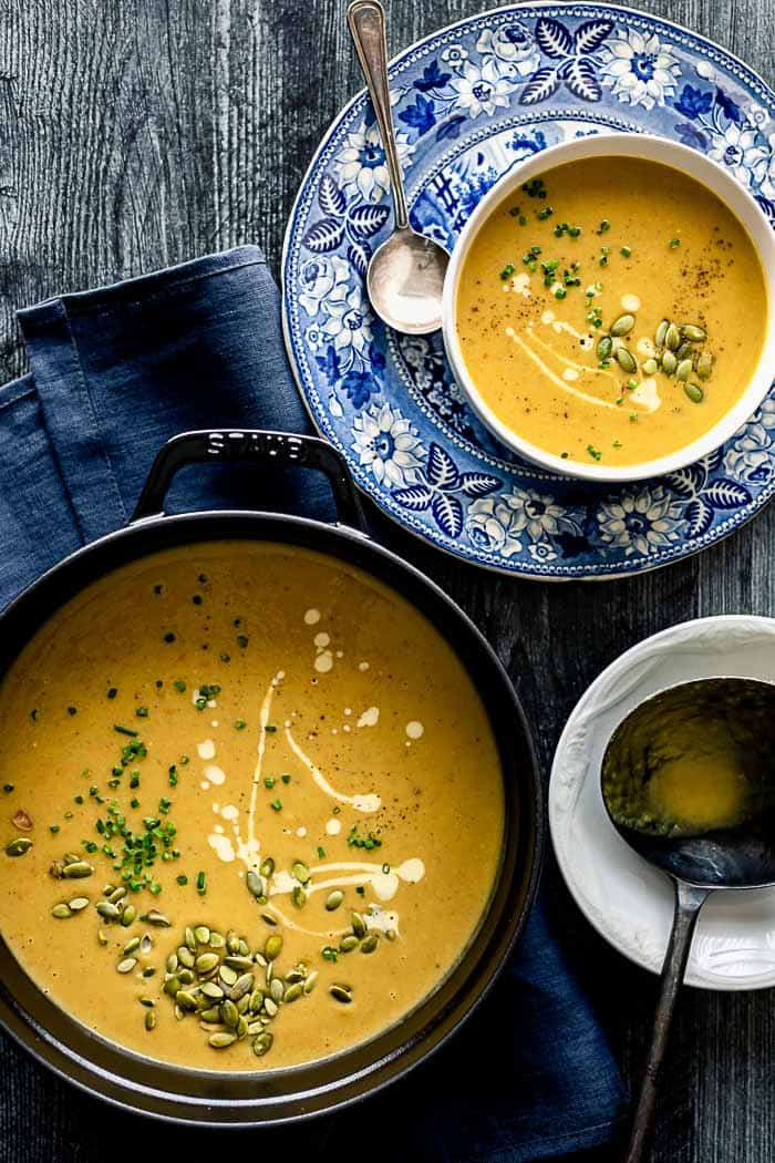 Vegan Pumpkin Soup in a black Dutch Oven with a serving of soup on the side