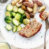 a plate with a slice of turkey meatloaf with potatoes and brussels sprouts