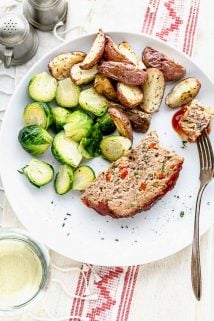 a plate with a slice of turkey meatloaf with potatoes and brussels sprouts