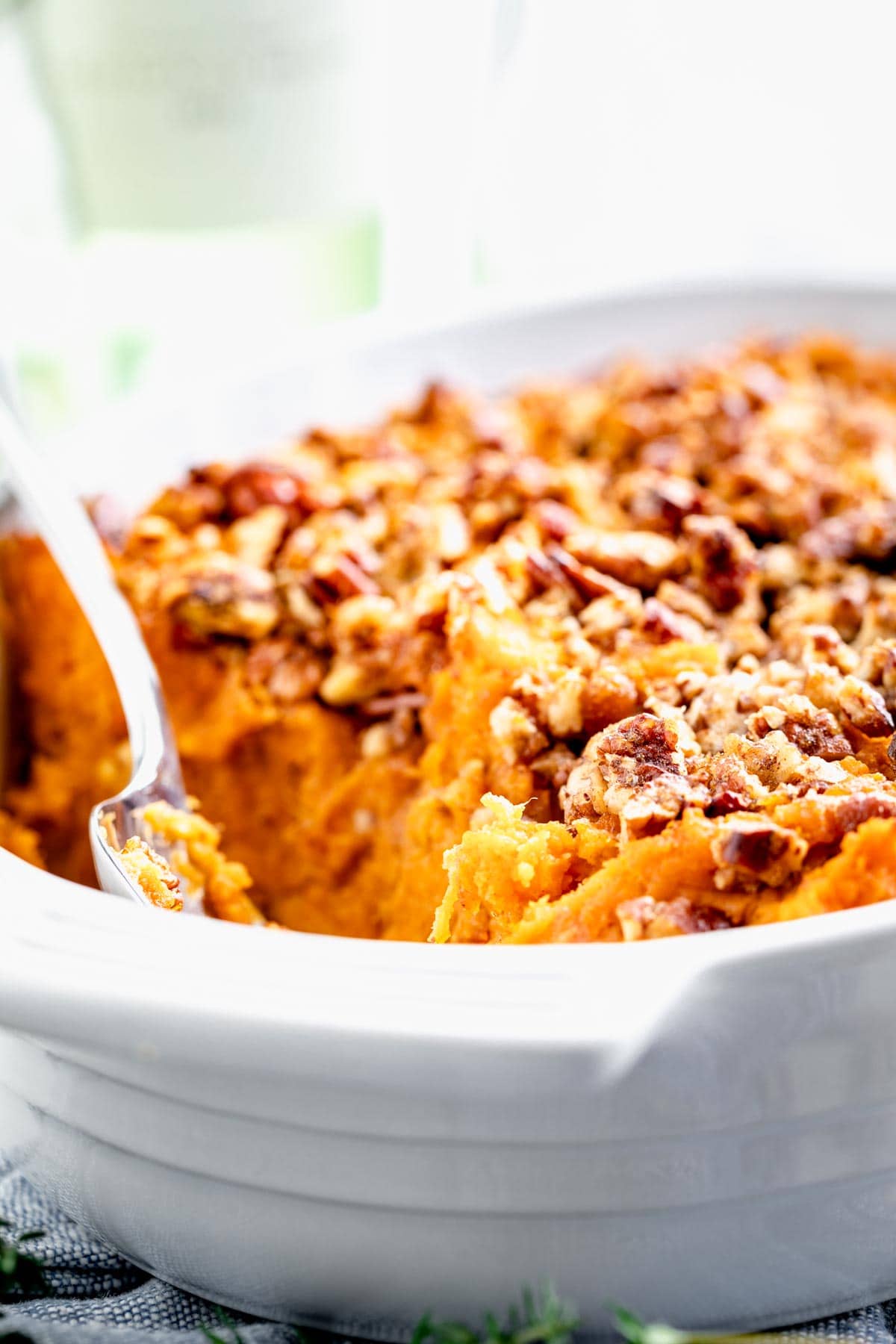 A close up side view of sweet potato casserole with pecans on top