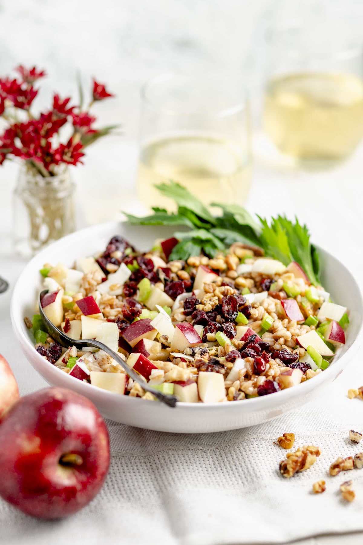 the salad after it has been stirred together with an apple in the foreground