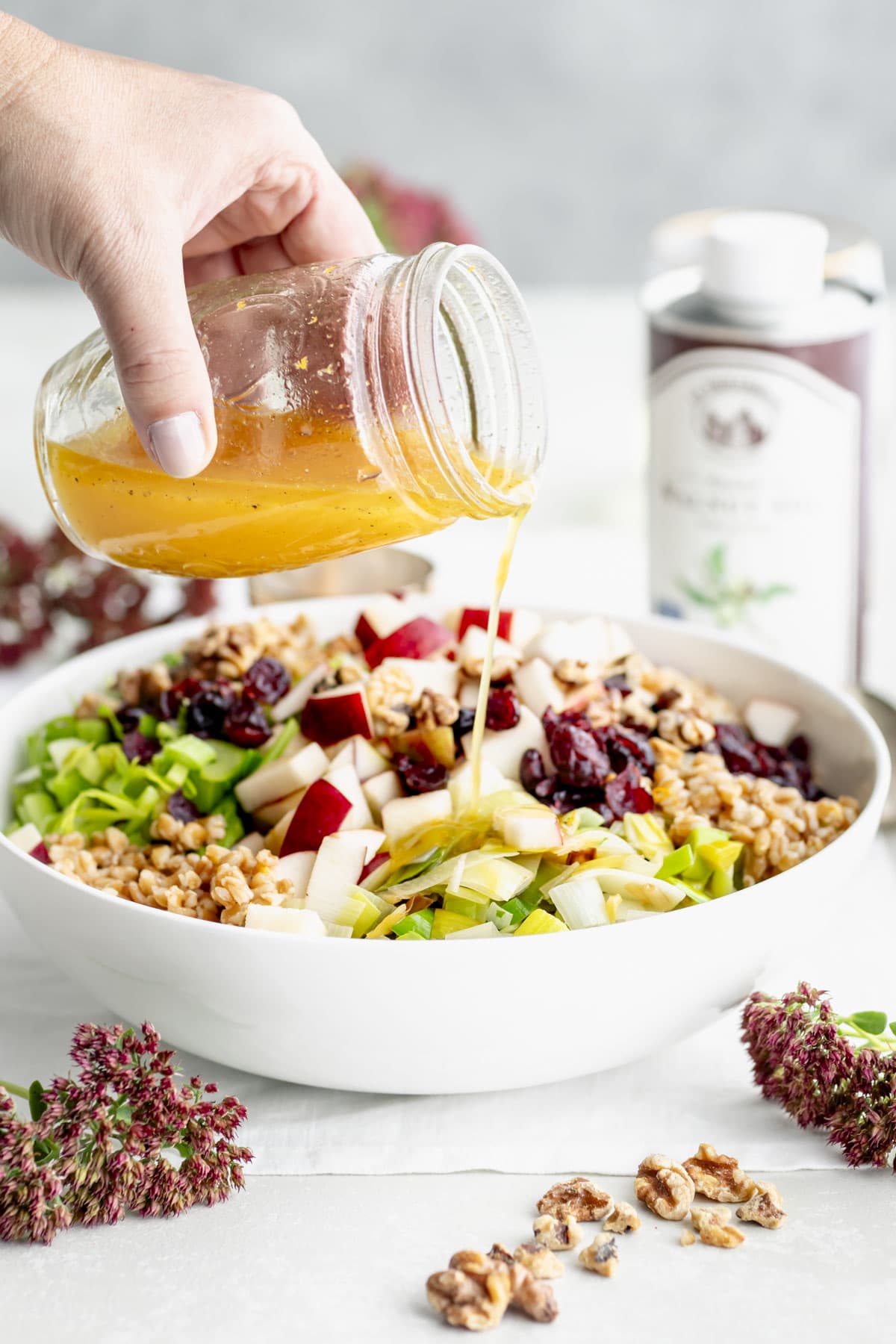 pouring the dressing over the salad