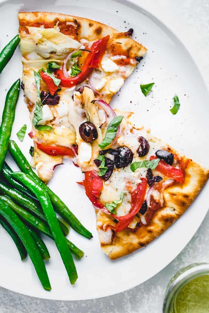 Greek Pizza slices on a plate with green beans