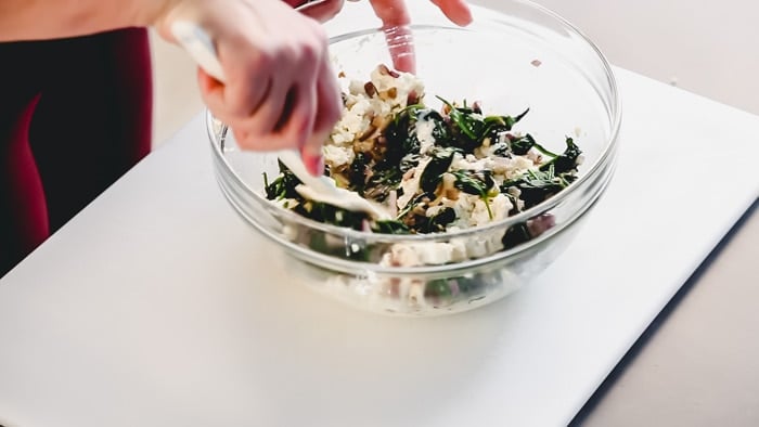 Adding the spinach to the ricotta mixture for shell stuffing