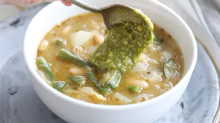 adding pesto to soup