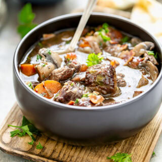 a closeup of the beef stew in a black bowl