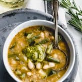 Soupe au pistou from overhead in a white bowl on a gray pie plate