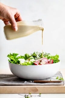 pouring dressing over salad