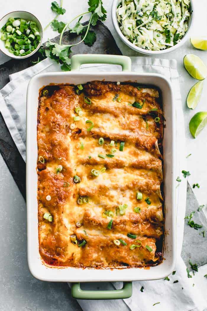 Overhead view of a casserole dish with baked chicken enchiladas