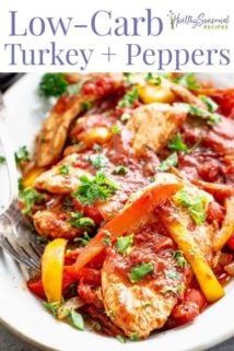 A close up of tomatoes and peppers with turkey on a white platter