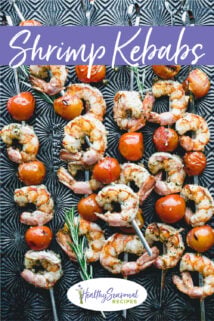 tomatoes and shrimp on kebabs on a black sheet pan