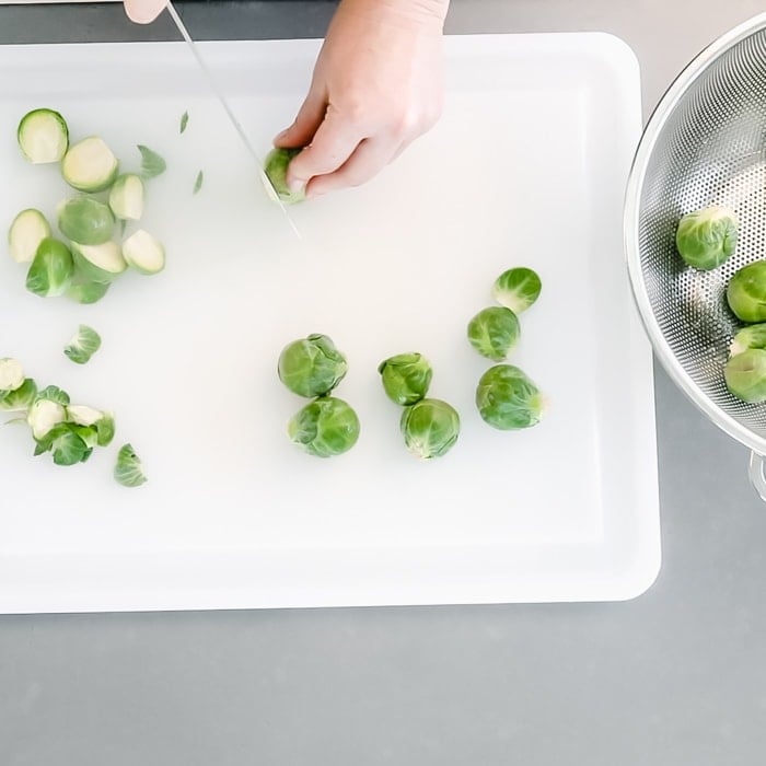 Trim the ends and cut the Brussels in half.