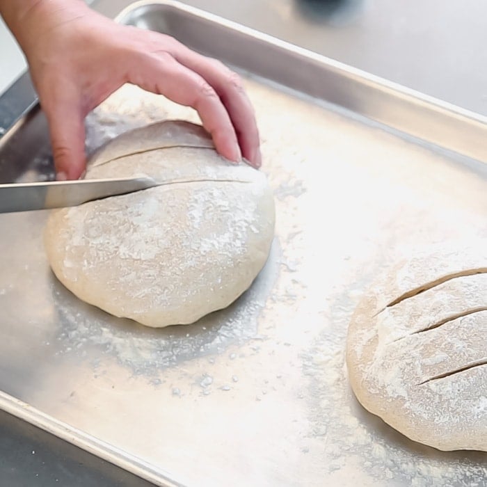 Dust the balls with flour and slash the tops