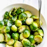 a white bowl with cooked brussels sprouts