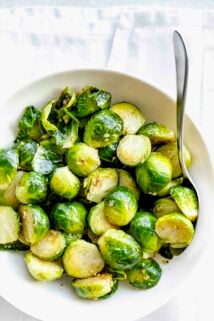 a white bowl with cooked brussels sprouts