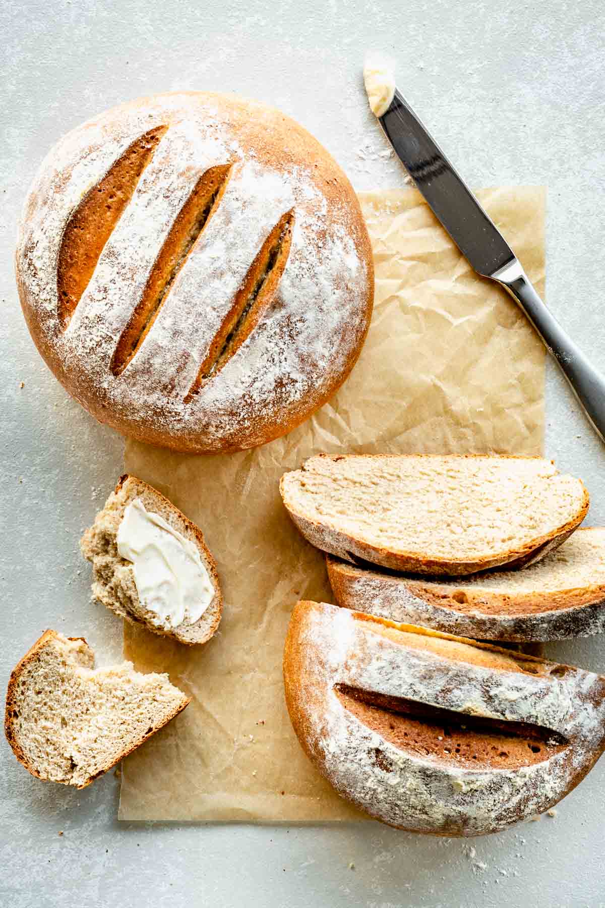 two loaves of bread, one is whole the other is cut and buttered