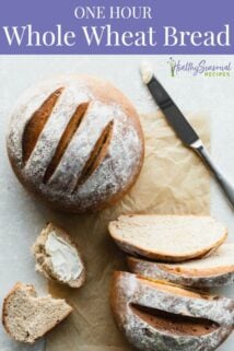 Whole loaf and cut loaf of bread on parchment paper next to knife