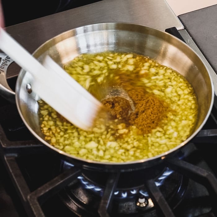 add cumin to the garlic and oil