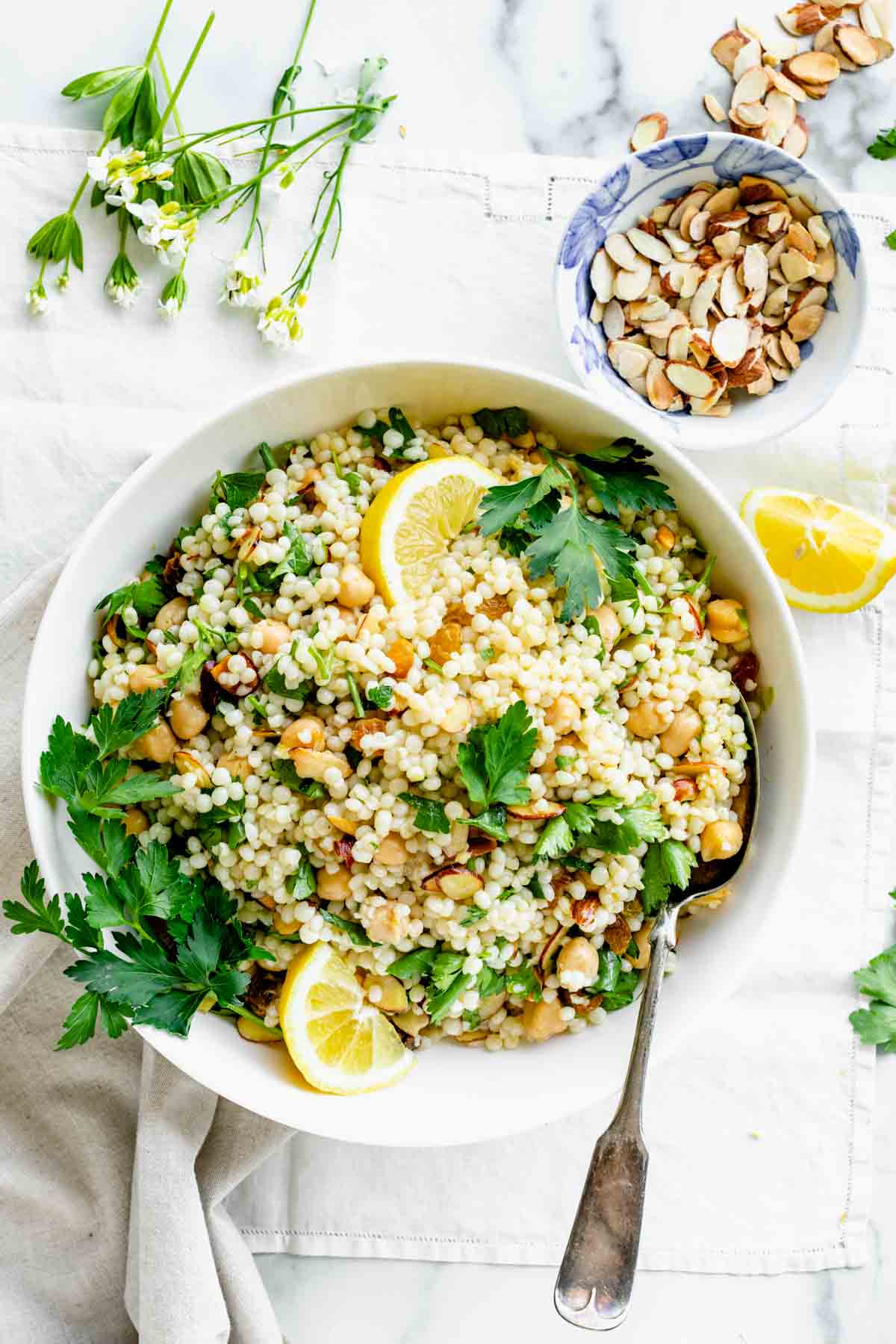 overhead of couscous salad garnished with lemon wedges