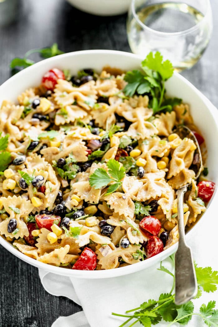 the pasta salad with a spoon in the side of the bowl