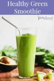 Green smoothie on a wood cutting board surrounded by ingredients