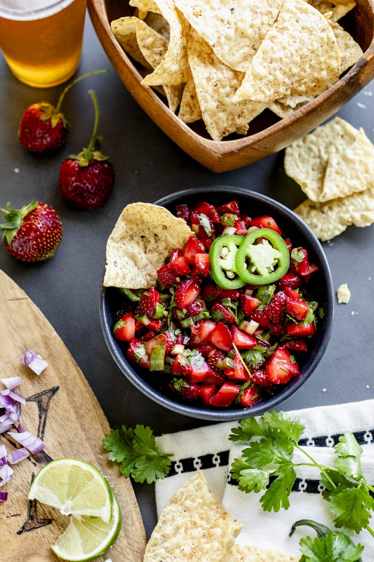 a black bowl with strawberry salsa garnished with jalapeno rings