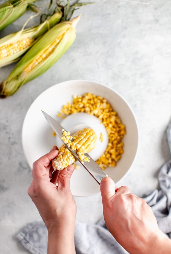 cutting kernels off the ear of corn